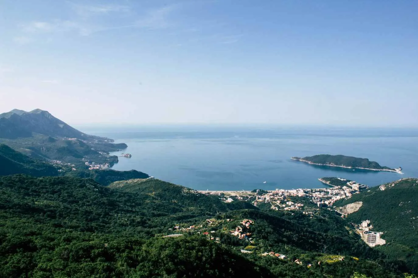 Marina on the Montenegro coast with moored yachts, palm trees and mountains in the background